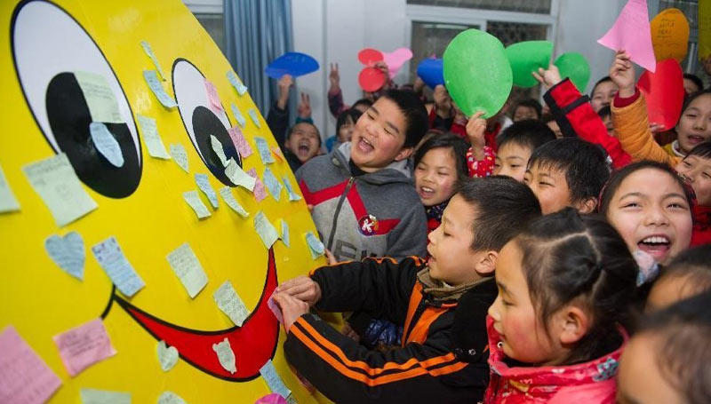 2月16日，在合肥市隆岗小学，学生们将写满新学期寄语的卡纸贴在“笑脸”上。当日，合肥市中小学校迎来开学日，各个学校以不同的方式迎接返校的学生们。