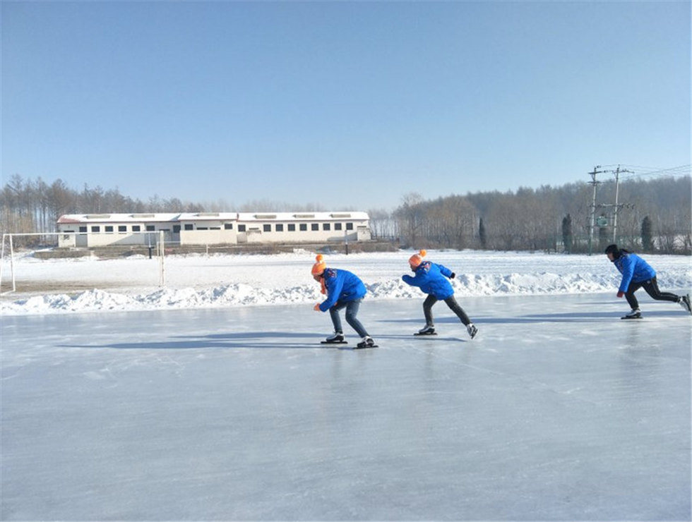 2018年，黑龍江黑河嫩江縣長福學校，孩子們換上溫暖包裡的衣服和志願者在冰場上滑冰。（攝影：盧文丹）