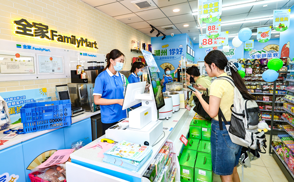 全家FamilyMart门店内店员为顾客收银。（受访者供图）