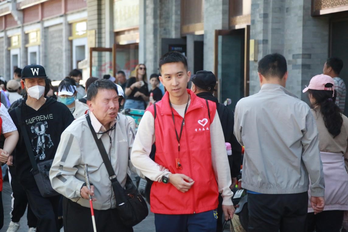 农银人寿青年志愿者与视障朋友深入交流，并引导视障朋友参观中轴线。