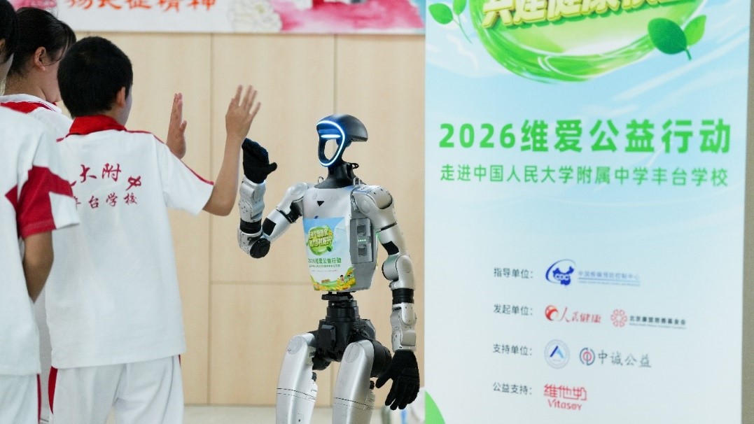 同学们在维爱公益行动现场与机器人挥手互动。